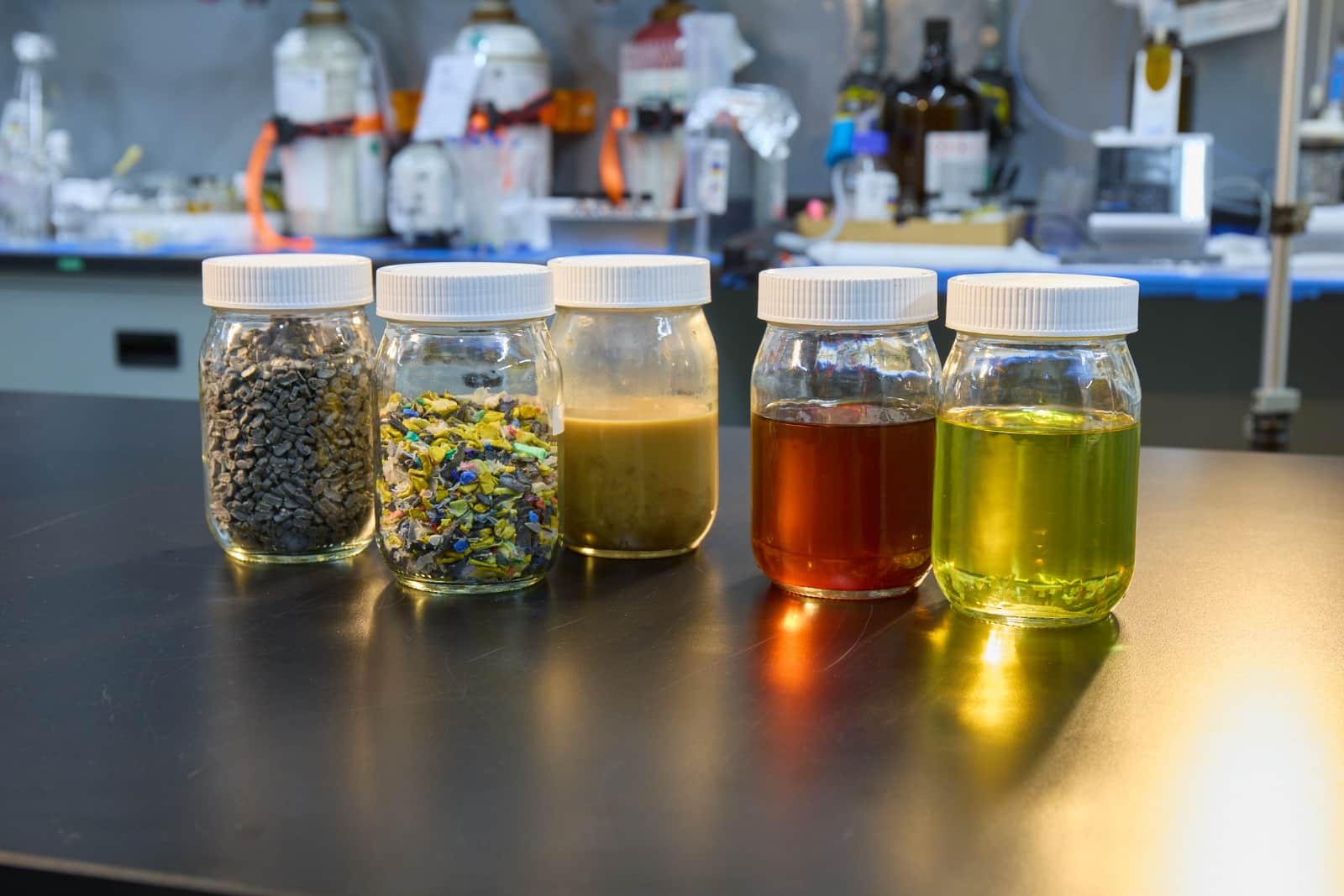 Glass jars showing plastic feedstock and the liquid hydrocarbon products made from it